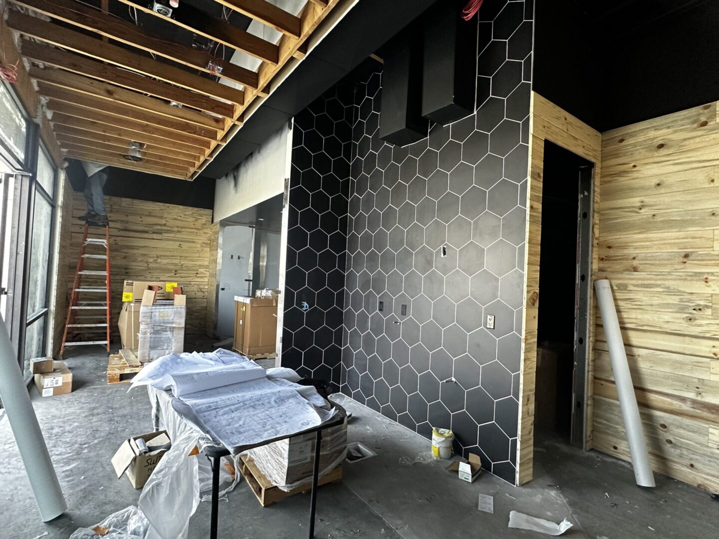 A room with black walls and white honeycomb tile.